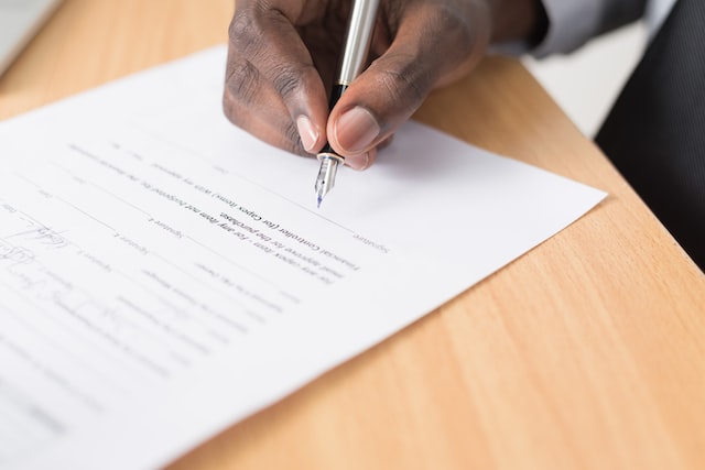 Close up of a hand signing a document with a fountain pen